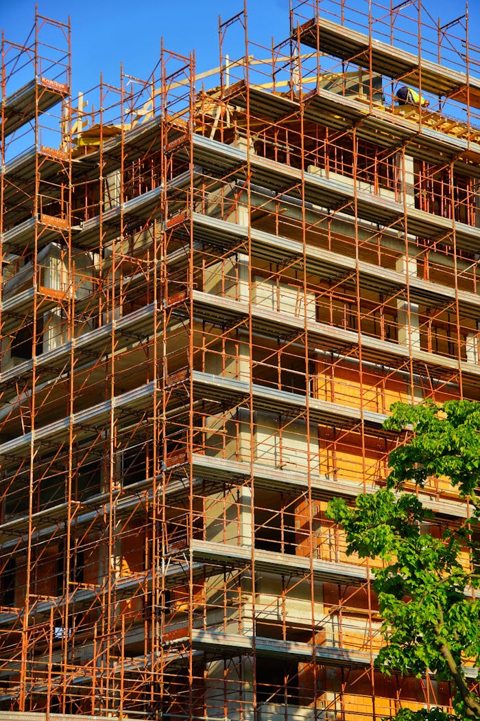 A multi-story building under construction with scaffolding on a sunny day.